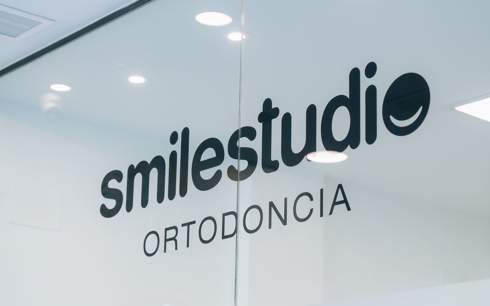 Rótulo de Smilestudio Ortodoncia en la puerta de la clínica